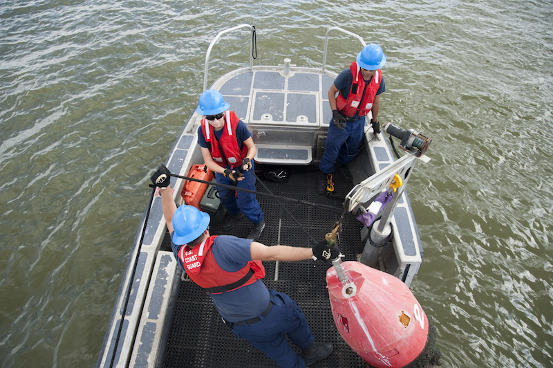 HOUSTON - (From left) Fireman Raymond Hatfield, Seaman Carol Root and Petty Officer 3rd Class Ismael Villanueva work a navigational buoy in the San Jacinto River October 6, 2011. The three are are assigned to Aids to Navigation Team Galveston, a unit that handles aids to navigation in the Houston Ship Channel. Coast Guard photo by Petty Officer 2nd Class Prentice Danner.
